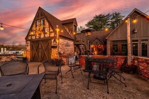 A rustic building with a brick facade, wooden beams, and outdoor seating. - Longacre of Appomattox (Appomattox)