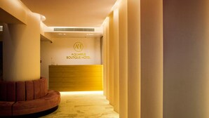 A reception area with a wooden reception desk and a sign reading "Aquarius Boutique Hotel". - Aquarius Boutique Hotel (Rethymno)