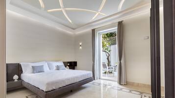 Un dormitorio moderno con una cama grande, una mesita de noche, una lámpara de pared y vistas a un espacio exterior a través de una puerta de vidrio.