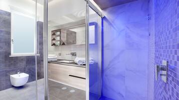 Une salle de bain moderne avec une douche à parois de verre, un lavabo et un meuble-lavabo avec un miroir.