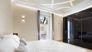Un dormitorio moderno con una cama grande, una puerta corrediza de vidrio a un balcón y un armario empotrado.