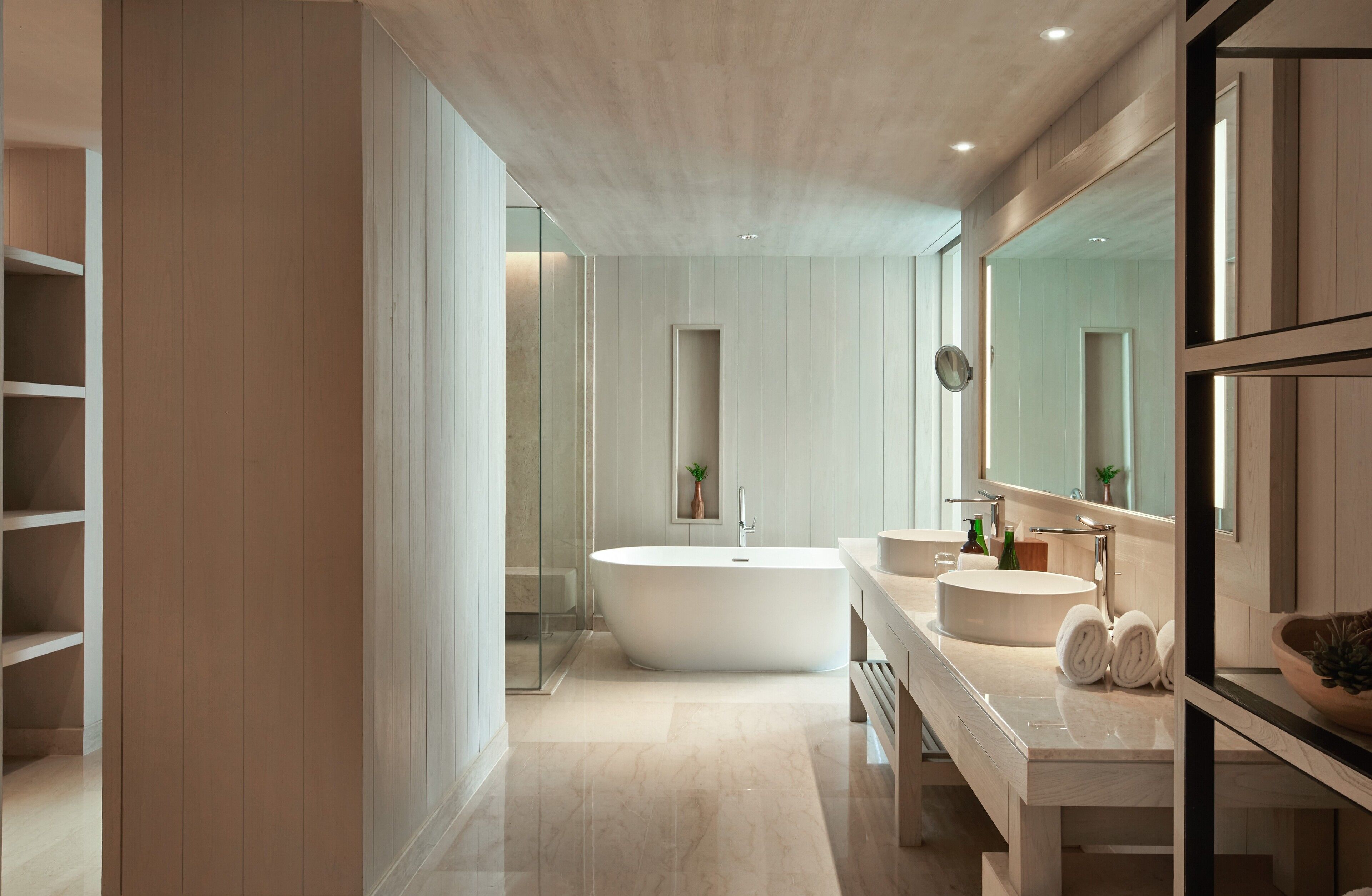 A modern bathroom with a freestanding bathtub, a vanity with a sink, and a large mirror.