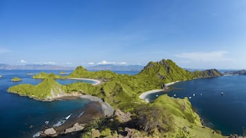 A coastal landscape with green hills and clear blue waters.