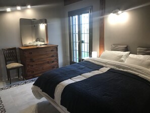 A bedroom with a bed, dresser, chair, and a large window. - La Collina delle Fonti (Aprilia)