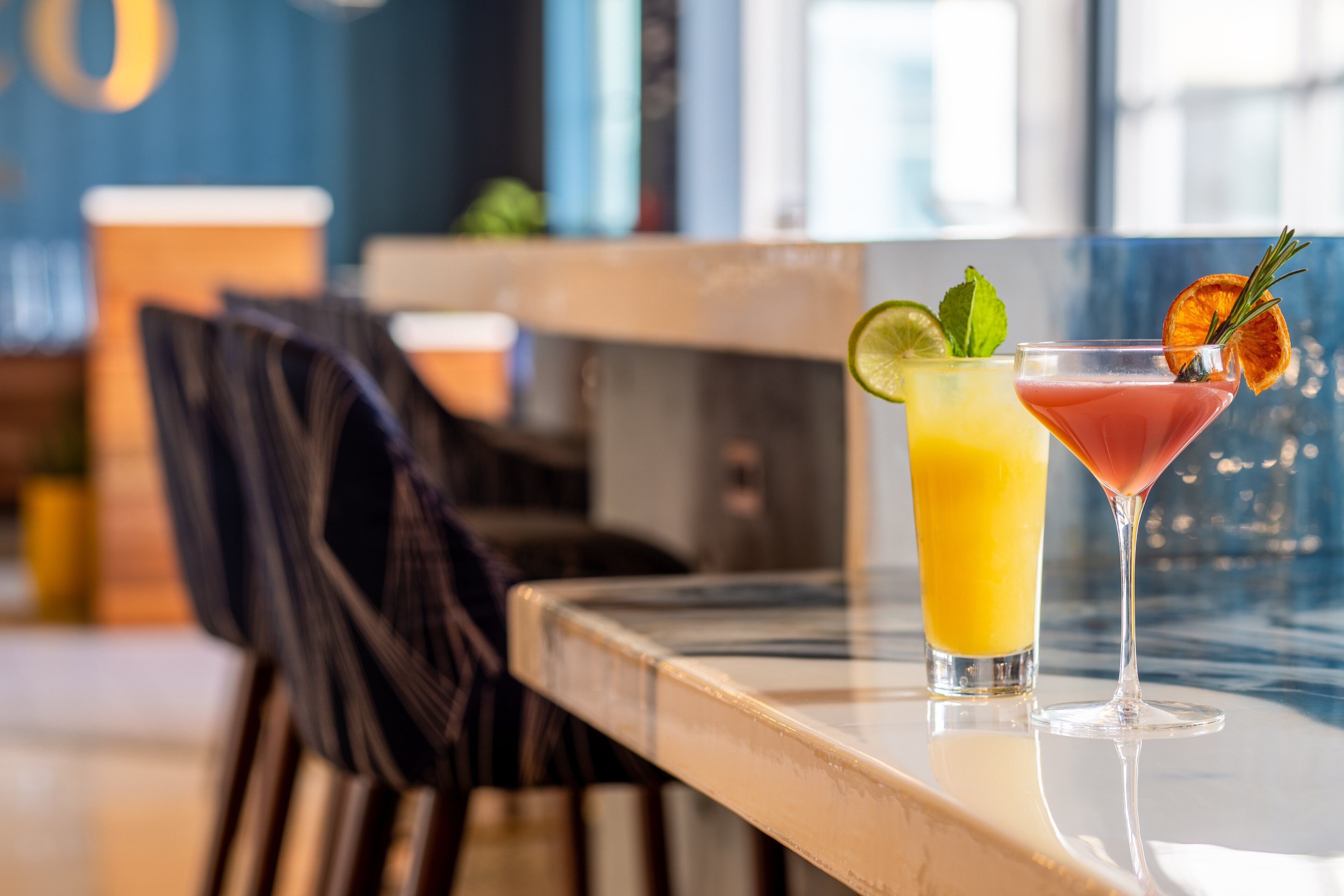 Deux boissons sur une table, avec une chaise en arrière-plan.