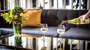 A glass table with two wine glasses and a bottle of wine being poured into one. - voco St. Augustine Historic Area by IHG (St. Augustine)