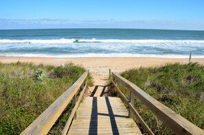 A wooden boardwalk leading to a sandy beach with ocean waves in the background. - voco St. Augustine Historic Area by IHG (St. Augustine)