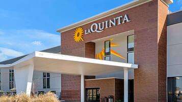 A La Quinta hotel with a modern design, featuring a prominent sun logo and the name 'La Quinta' above the entrance.