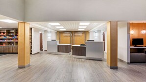 A spacious lobby with a reception desk, a seating area, and a bookshelf. - La Quinta Inn & Suites by Wyndham Columbus MS (Columbus)