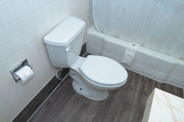 Un baño con inodoro, rollo de papel higiénico y bañera.