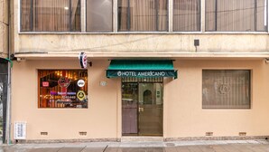 Een hotel met een groen luifel, een duidelijke ingang en een etalage met verschillende borden.
