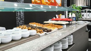 Un bufé con diferentes opciones de comida y recipientes con salsas.