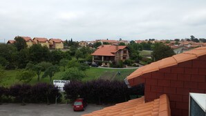 A residential area with houses, a signboard, and a red car.