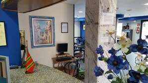A reception area with a computer desk, framed artwork, and a flag.