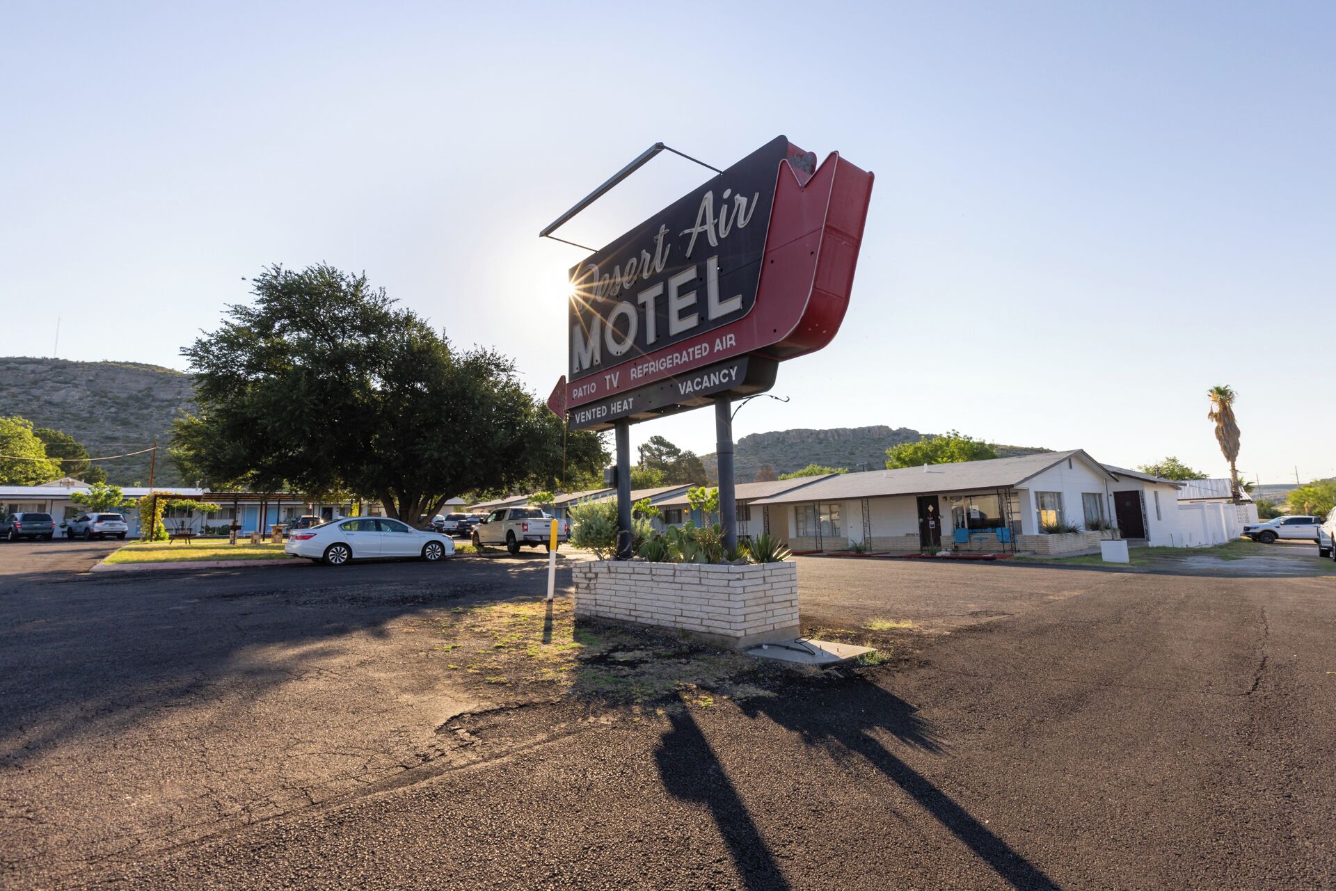 A Desert Air Motel sign with amenities including a patio, TV, refrigerated air, and vented heat.