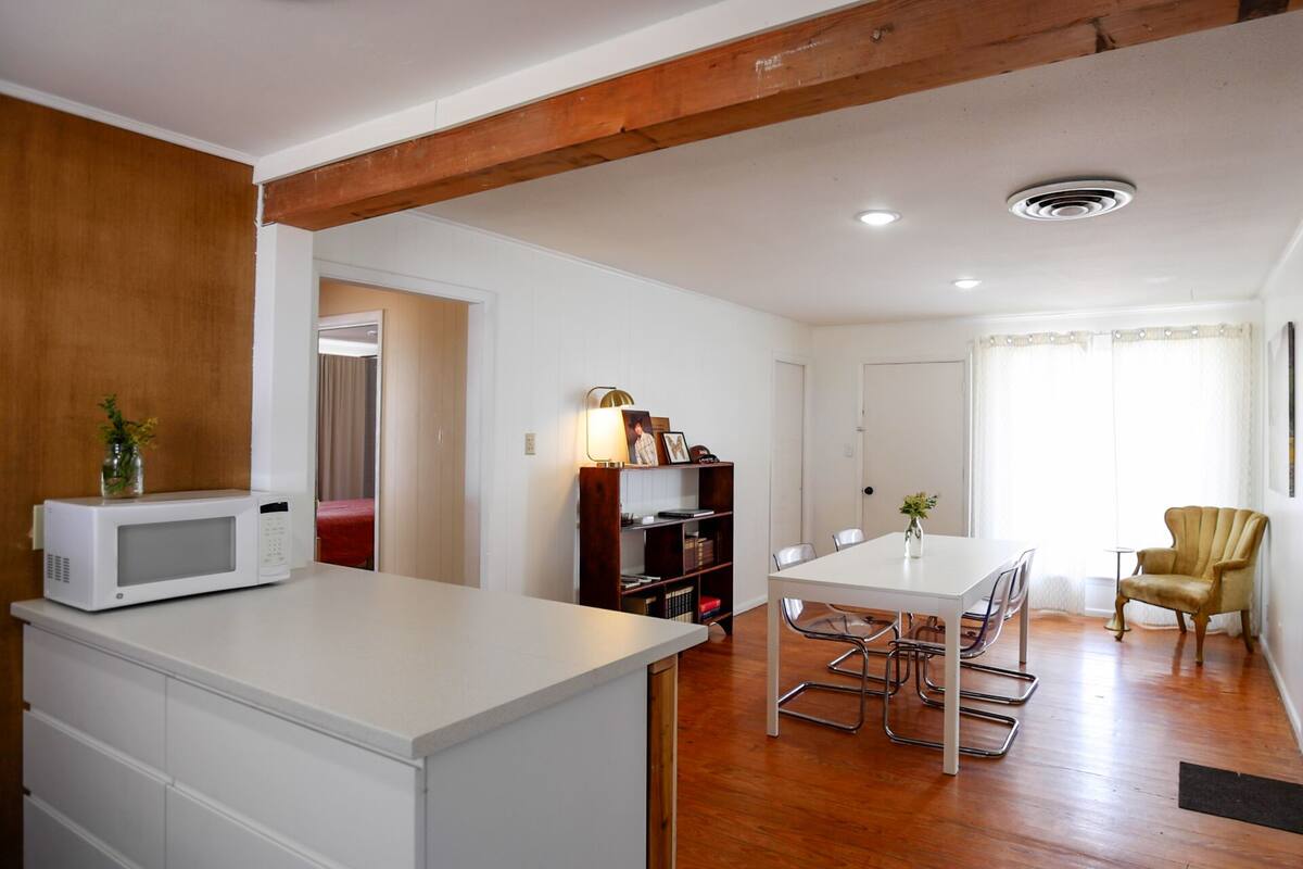 A compact living space with a kitchenette, a dining area, and a small seating area.