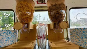 A cereal dispenser with two compartments, one for cornflakes and one for crispy flakes, and a sign for Desert Air Motel. - Desert Air Motel (Sanderson)
