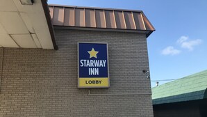 A Starway Inn sign on a brick wall, indicating a lobby area. - Starway Inn (Lansing)