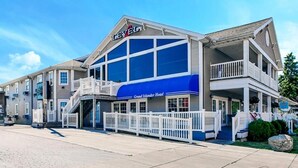 A two-story Grand Islander Hotel with a blue awning, white railings, and a balcony on the upper floor. - Grand Islander Hotel (Put-in-Bay)