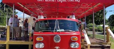 A vintage fire truck with a red canopy labeled "LAST RESORT ENGINE COMPANY" parked outdoors.