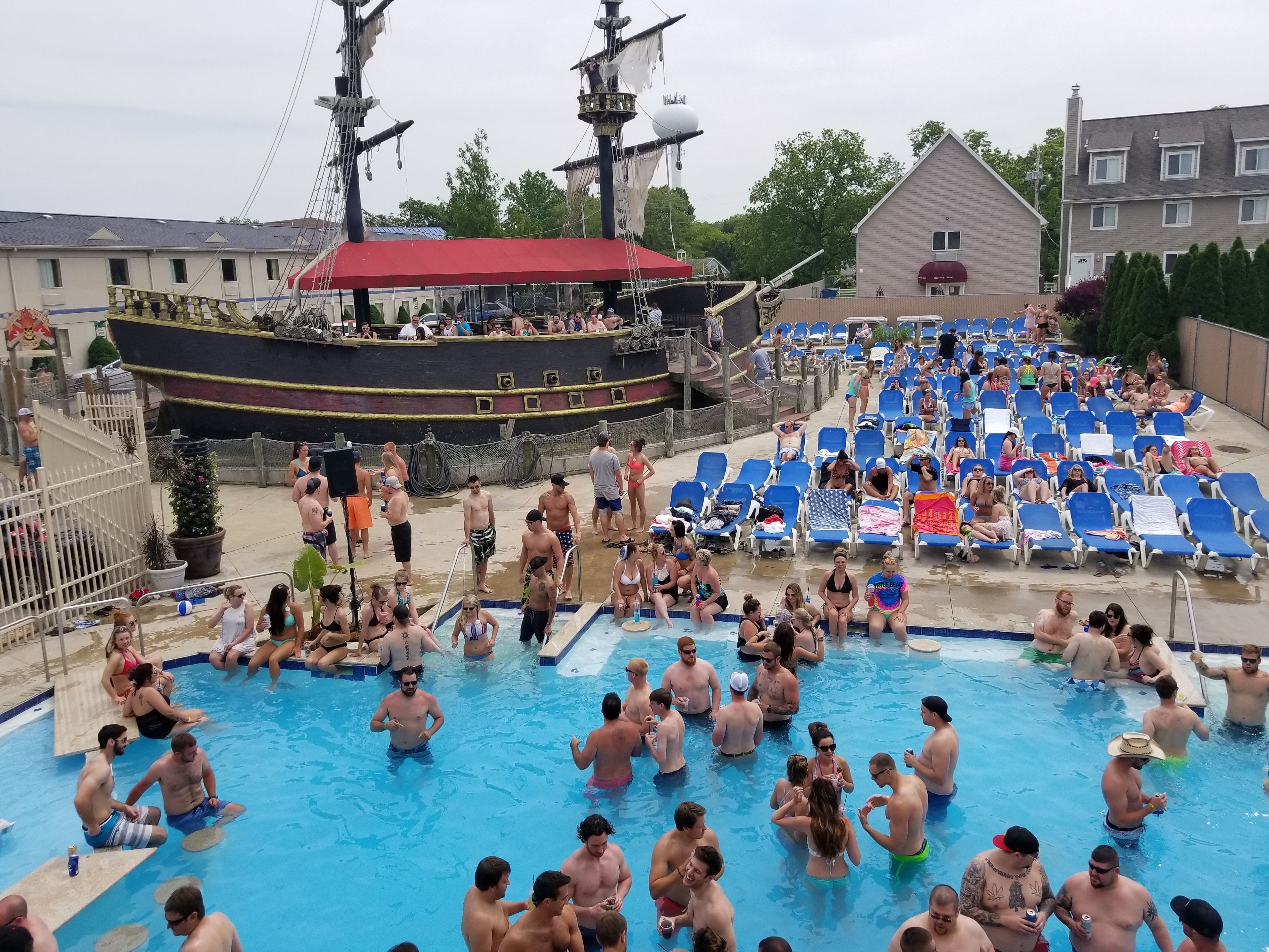 A swimming pool area with a large ship model and lounge chairs.