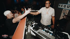 A DJ booth with electronic equipment, a sign that reads "REQ", and a crowd in the background. - Grand Islander Hotel (Put-in-Bay)