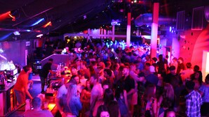 A crowded bar with people standing and socializing. - Grand Islander Hotel (Put-in-Bay)