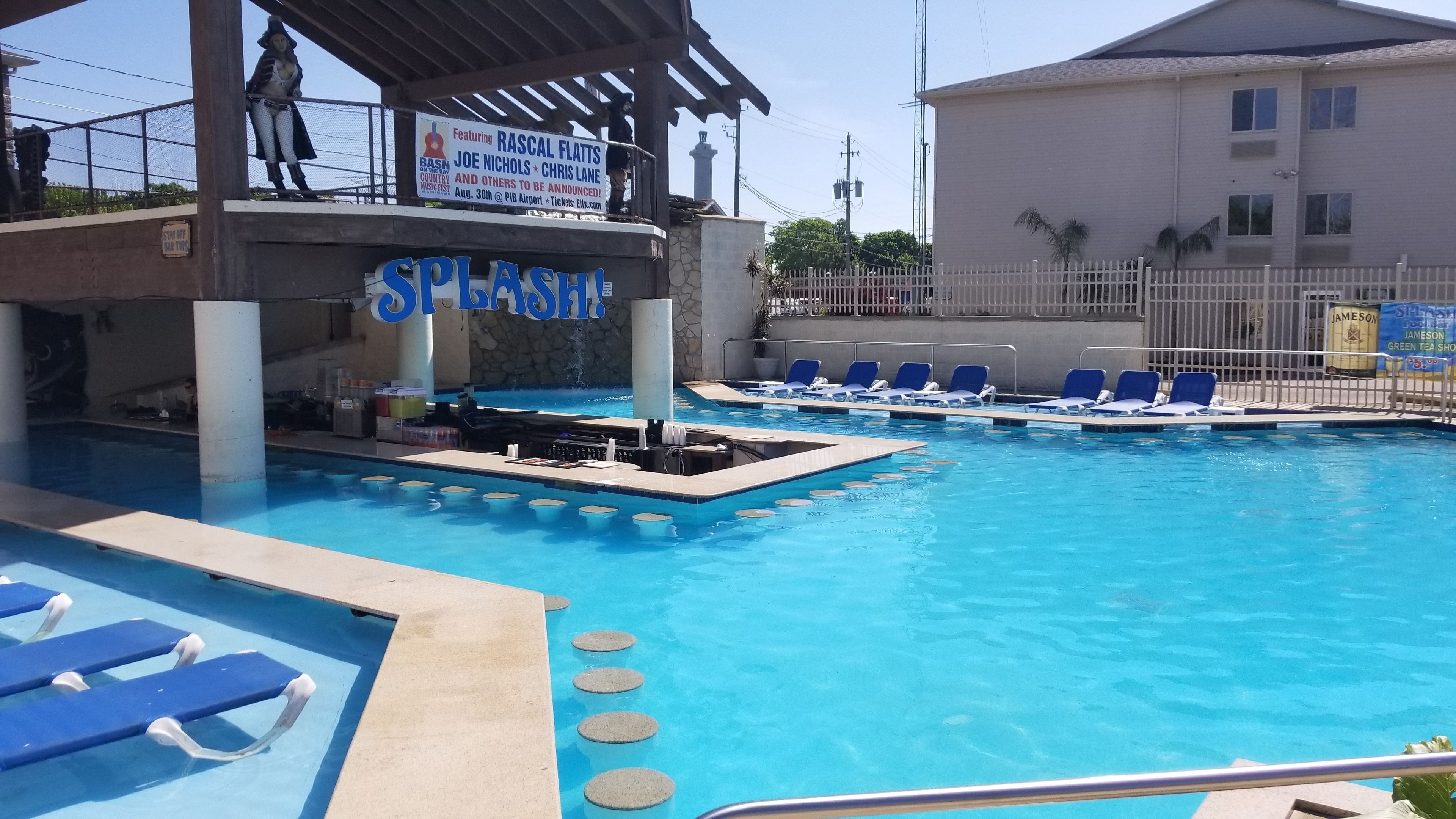 Zona de piscina amb gandules i un escenari per a actuacions.