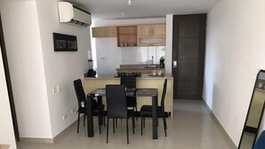 Une cuisine moderne avec un îlot central, un coin repas avec des chaises et un canapé.