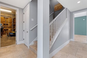 A clean, modern interior with a staircase, a door leading to a garage, and a view of the garage area. - Grande Palermo – Come stay and experience coastal living at its best! (Fort Myers Beach)