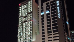 Un edificio de varios pisos con señalización iluminada, que incluye “Business Bay” y “TOWER”.