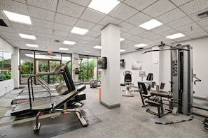 A gym with treadmills, weight machines, and exercise mats.