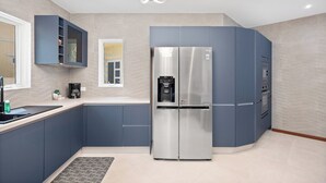 A modern kitchen with a built-in double refrigerator, a coffee maker, and a water dispenser.
