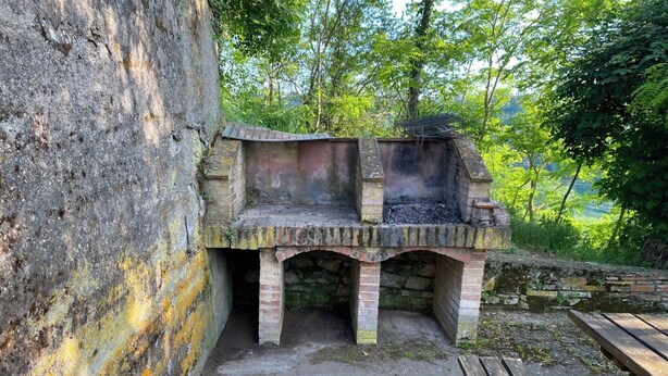 An outdoor brick barbecue area with a wooden bench nearby. - 2bed, 1bath Garden apt in Chianti! (Frazione Mura, Montaione)
