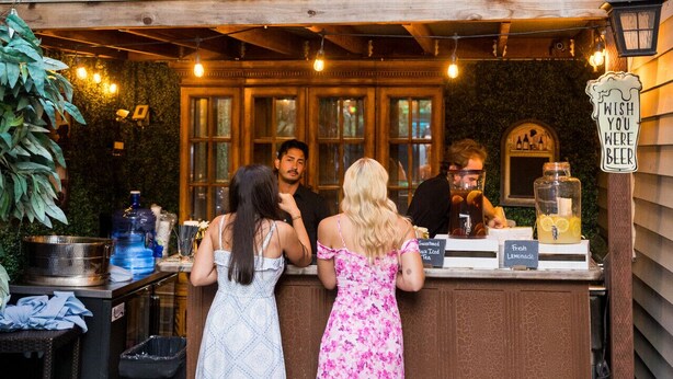 An outdoor bar area with a rustic wooden counter, a sign reading "Wish you were beer," and a menu board displaying "Sweetened Black Tea" and "Fresh Lemonade." - Cozy 10 guest, 4 Bedroom, 2 Bath, Pet Friendly, 2-minute walk to downtown Julian (Julian)
