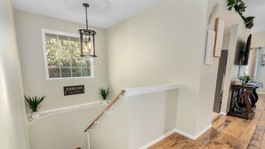 A staircase with a wooden handrail and a white baseboard, leading to a landing with a window. - Cozy 10 guest, 4 Bedroom, 2 Bath, Pet Friendly, 2-minute walk to downtown Julian (Julian)