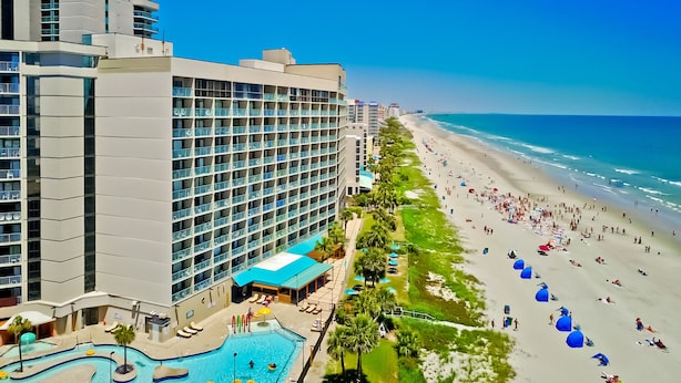 Een hotel met zwembad, toegang tot het strand en uitzicht op de oceaan.