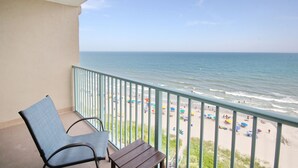 Een balkon met uitzicht op het strand en de oceaan.