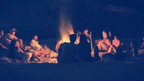 En grupp människor samlades runt en lägereld på en mörk plats.
