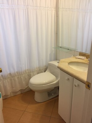 Un baño con inodoro, lavabo y espejo.