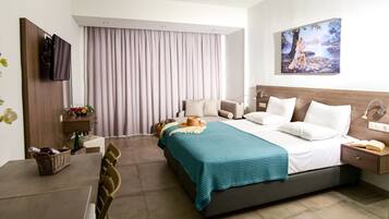 A modern hotel room with a large bed, a desk, a chair, a TV, a painting, and a window with curtains.