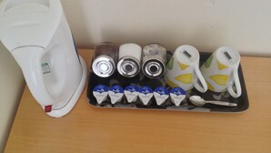 Un plateau avec une machine à café, trois boîtes et plusieurs briques de lait.