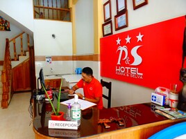 Un mostrador de recepción de hotel con un cartel que dice "P&S HOTEL PAMPA & SELVA".