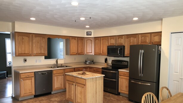 A spacious kitchen with wooden cabinets, stainless steel appliances, and a central island. - Magnificent & Spacious Condo for All of Your PSU Vacations 4.5 Miles from Campus (State College)