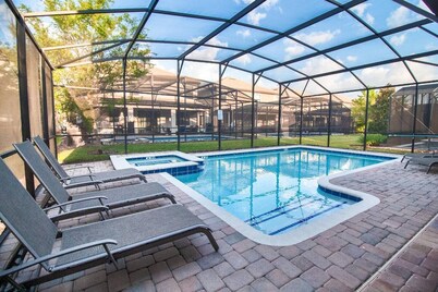 Walk to Oasis Club from this 9B/5B Champions Gate villa! Private pool, spa, sleeps up to 30.