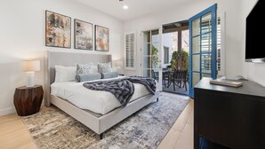 Quarto com cama, ventilador de teto, televisão e obras de arte na parede.