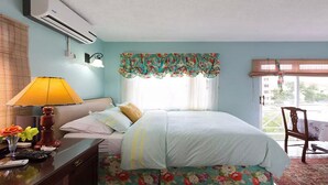 A bedroom with a bed, a desk with a lamp, a chair, and a table with a vase of flowers. - Habitacion moderna y acogedora de Azur (Kingston)