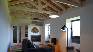 A living room with a sofa, a fireplace, a TV, and a lamp. - Traditional house restored in private and quiet environment near the sea (Terra Alta)