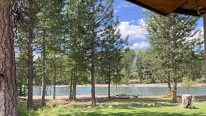 Vista de un río con árboles y una zona cubierta de hierba.