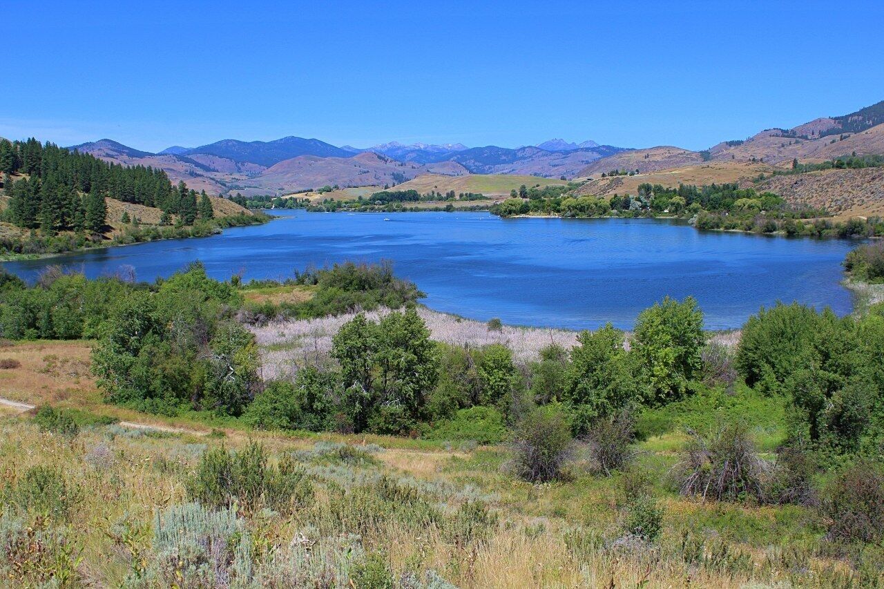 Un lago circondato da colline e alberi.